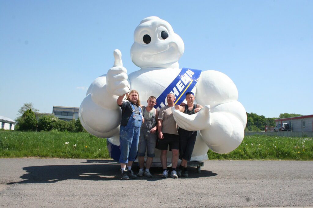 A group of people in front of the oversized plastic figure  