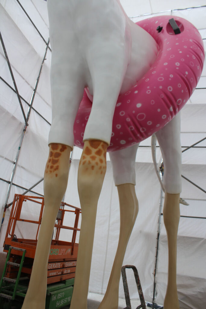 Photorealistic painting of the giant giraffe made of plastic (CFRP)