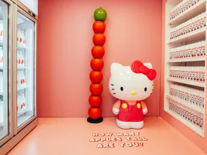 Eine große Hello Kitty Figur aus Kunststoff steht zwischen den Regalen